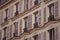 Beautiful facade of a building from Paris, France, with a lot of plants and elegant architecture details and decorations.