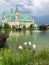 Beautiful fairytale castle by the lake. A group of pink flamingos hunting in the pond.