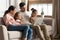 Beautiful family with children resting with laptop on couch