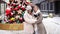 Beautiful family with dog Papillon near Christmas tree on street.