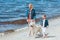 beautiful family with golden retriever dog on walk near the sea