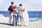 Beautiful family together forever at the beach with a sunny day and surfer teenager - looking at the sea and the sky with surf