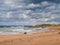 Beautiful Fanore beach, Yellow sand, blue water and cloudy sky, Waves rushing towards the coast, County Clare, Ireland