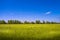 Beautiful farm landscape, wind turbines to produce green energy and electrical power lines in Germany, summer, blue sky