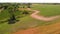 Beautiful farmlands with a dirt road and wheat field. Aerial view.