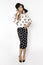 Beautiful fashion model, dressed in pinup style black dress in white polka dot, isolated over white background. Caucasian trendy