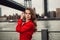 Beautiful fashion model woman posting in New York City wearing red jacket.