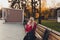 Beautiful Fashion Woman with handbag sitting and waiting on a bench in the park and drink water.