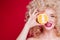 Beautiful fashionable blonde girl in retro style with voluminous curly hairstyle, open shoulders and an orange in her hands,