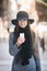 Beautiful fashionable business woman walking on the street and texting on mobile phone