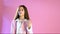 Beautiful fashionable girl poses on a pink background