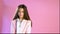 Beautiful fashionable girl poses on a pink background