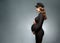 Beautiful fashionable girl pregnant in studio stands posing