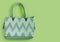 Beautiful fashionable green bag on delicate paper background