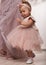 Beautiful fashionable little baby in pink dress. little princess poses like a doll