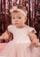 Beautiful fashionable little baby in pink dress. little princess poses like a doll