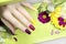 Beautiful fashionable multi-colored manicure with matte and glossy nail Polish colors with decorative small flowers