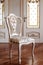 Beautiful and fashionable, Vintage Wooden chair in the room. object furniture in classic style. white tree with gold trim. patina.