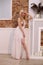 Beautiful fashionable woman girl blond standing in the room in a white dress