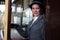 Beautiful female in 1920s costume with cloche hat leaving train at station and smiling at camera