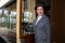 Beautiful female in 1920s costume with cloche hat leaving train at station and smiling at camera