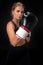 Beautiful female athlete in boxing gloves, in the studio on a black background. Focus on the glove