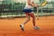 Beautiful female athlete with perfect body posing on tennis court, close up