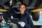 Beautiful female auto mechanic checking wheel tires in garage, car service technician woman repairing customer car at automobile