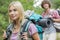 Beautiful female backpacker looking away with man in background at forest