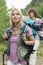 Beautiful female backpacker looking away with man standing in background at forest