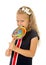 Beautiful female child with long blond hair holding huge spiral lollipop candy smiling happy