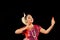 Beautiful Female Classical Odissi dancer performing Odissi Dance on stage at Konark Temple, Odisha, India.