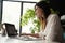 Beautiful Female Data Analyst sitting at the Table Works on a Laptop. Stylish Woman in the Modern Office Environment.