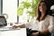 Beautiful Female Data Analyst sitting at the Table Works on a Laptop. Stylish Woman in the Modern Office Environment.