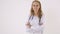 Beautiful female doctor in white coat looking at camera and smiling while standing with crossed arms