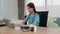 Beautiful female doctor working with laptop at clinic office.