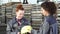 Beautiful female factory worker receiving a hardhat from her colleague