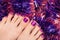 Beautiful female feet with purple pedicure on christmas background