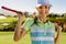 Beautiful female golfer holding golf club on field