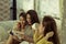 Beautiful female group three friends happily enjoy on sofa with fun in living room at home with bright smile morning,with warm