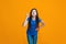 Beautiful female half-length portrait on orange studio backgroud. The young emotional teen girl