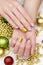 Beautiful female hand with beige nail design. Christmas manicure.