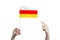 A beautiful female hand holds a South Ossetia flag to which she shows the finger of her other hand, isolated on white background