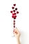 Beautiful female hand with trendy red manicure holding champagne glass with vibrant red heart-shaped confetti poured out