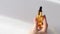 Beautiful female hand twirls in her hand and puts a small bottle with a pipette with golden colored oil