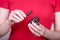 Beautiful female hands holding brown wooden ratchet money toad on a red background. Prosperity concept