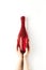 Beautiful female hands with trendy red manicure holding champagne bottle in cover spangled with vibrant red sequines on