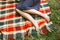 Beautiful female legs on a bright checkered plaid. Summer in the park