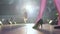 Beautiful female legs in high-heeled shoes go along catwalk in light lamps on fashion defile show