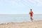 Beautiful female lifeguard running at sandy beach